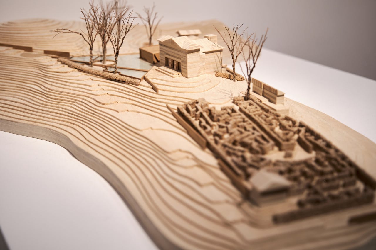 Intricate wooden architectural model showcasing design and topography in close-up view.